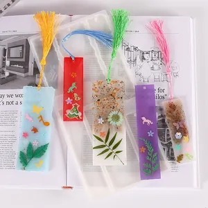 Nahaufnahme von handgefertigten DIY-Kristallharz-Lesezeichen mit bunten Quasten und Trockenblumen