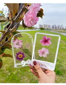 Detail view of transparent DIY dried flower bookmarks with aesthetic plant designs.