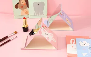 Gedetailleerd overzicht van schattige opvouwbare tafelspiegels met make-up kwasten