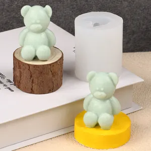 Detail showing 3D bear silicone mold with finished cute bear-shaped candles on wooden props
