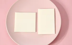 Detailed view of square and rectangular translucent sticky notes on a pink plate