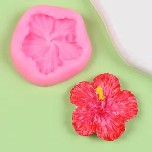 Detail showing pink silicone hibiscus mold with a finished red resin flower patch.
