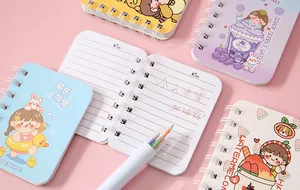 Detailed view of mini cartoon spiral notebooks with cute girl and fruit patterns