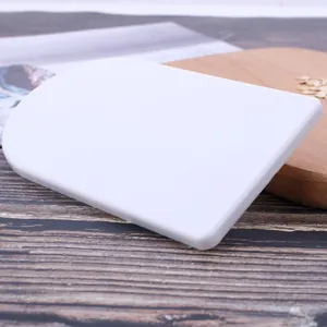 Vista dettagliata di una spatola per fondente in plastica bianca su una superficie di legno