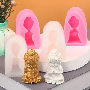Vue détaillée de moules en silicone en forme de Bouddha avec des statues dorées et argentées.