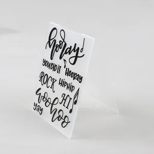 Detailed macro view of a translucent plastic embossing folder with positive hand-lettered text.