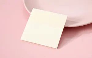Detail of translucent square sticky note on soft pink background showing texture