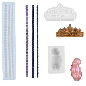 Detailed view of DIY silicone molds featuring bead string, crown, and baby shapes for resin