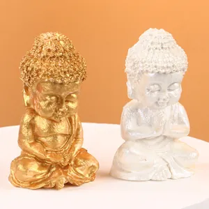 Paire de bougies statues de Bouddha avec finitions or et blanc nacré élégantes.