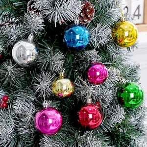 Bunte galvanisierte Weihnachtskugeln an einem verschneiten dekorativen Tannenbaum