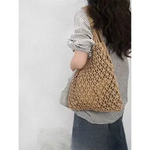 Bolso de playa de paja tejido a mano con gran capacidad en el hombro de la modelo
