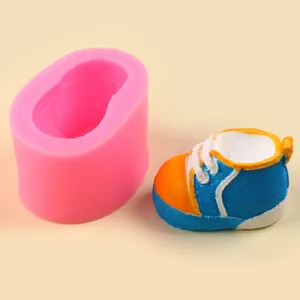 Detail view of a baby shoe silicone mold with a finished blue and orange resin model
