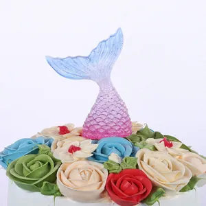 Close-up of a gradient blue and pink mermaid tail cake topper with glitter finish