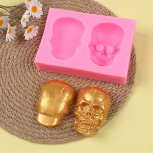 Detailed pink skull silicone mold with two golden skull casts for DIY Halloween craft projects