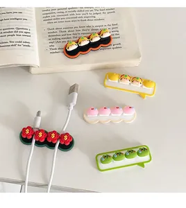 Detailed view of cute cartoon cable organizers on a desk with a book