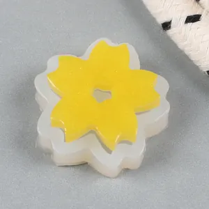 Macro view of yellow glitter sunflower resin piece with its white silicone mold