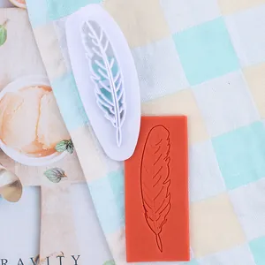 Gedetailleerd overzicht van een witte veer fondantsteker en zijn reliëfdeegpatroon