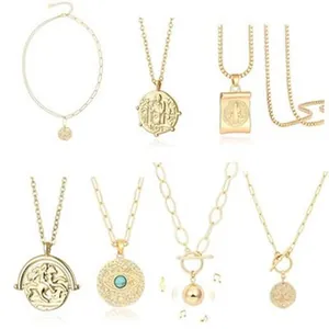 Detail view of various gold plated necklaces with coin, religious, and evil eye pendants.