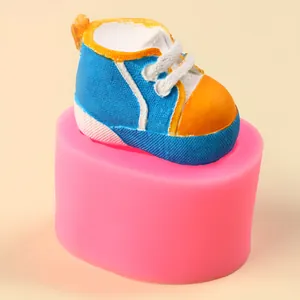 Detailed view of a baby shoe silicone mold with a colorful finished plaster shoe.