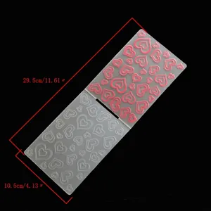 Macro detail of a plastic embossing folder with double heart patterns for DIY card making
