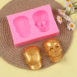 Close-up of pink skull silicone mold showing finished golden resin skull decorations