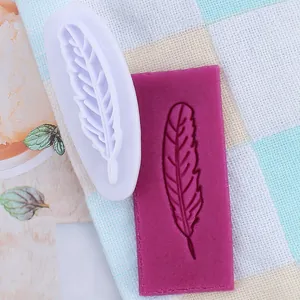 Detail van fondantvorm in de vorm van een veer met paars deeg