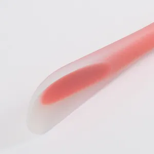 Close-up detail of translucent pink silicone spatula showing soft texture and curvature