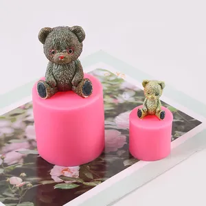 Detailed view of 3D teddy bear silicone mold with finished resin figures and candle molds.