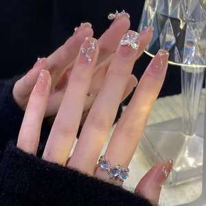 Detaillierte Nahaufnahme von Perlen-Schmetterlings-Aufpressnägeln mit Glitzerelementen.