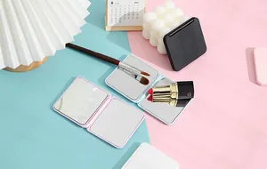 Close-up of portable square pocket mirrors in candy colors with makeup brushes.