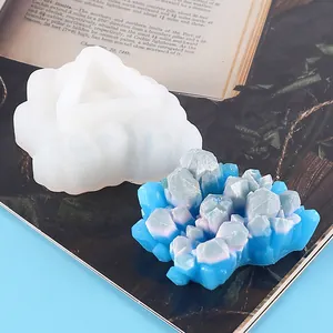 Detail view of white silicone mold and finished blue crystal resin cluster on book