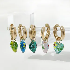 Primer plano de pendientes de aro con colgantes de corazón en cristal de colores