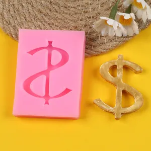 Macro view of pink silicone dollar sign mold with finished gold decorative craft piece