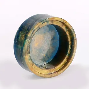 Close-up of finished round resin container with galaxy blue and gold foil texture.