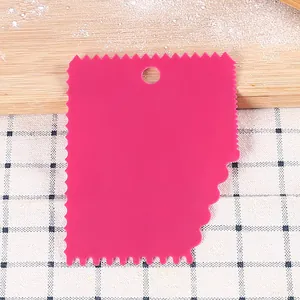 Detailed macro view of pink plastic dough scraper with serrated edges for baking