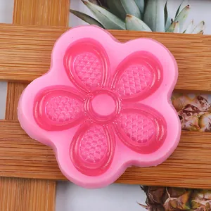 Macro detail showing the internal grid texture of the pink flower-shaped silicone mold.