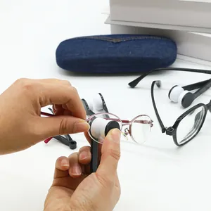 Close-up detail of a portable microfiber eyeglass lens cleaning tool wiping pink glasses