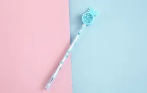 Close-up detail of a cute girl's sequin gel pen featuring light blue butterfly ornaments