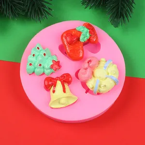 Detalle de un molde de silicona rosa navideño con figuras de árbol, campana y calcetín.
