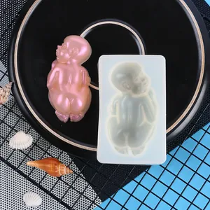 Detailed view of baby-shaped silicone mold with finished pink pearlescent resin figure