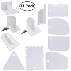 11-piece set of white plastic cake scrapers with various decorative serrated edges.