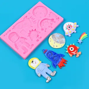 Close-up of pink space-themed silicone mold with finished astronaut and rocket samples