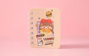 Detailed close-up of mini cartoon spiral notebook with cute girl and bunny illustration