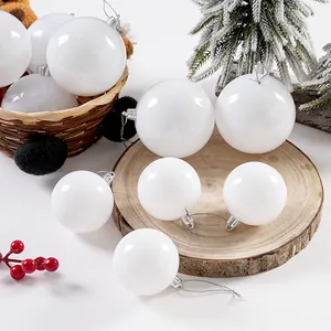 Verschiedene weiße glänzende Weihnachtskugeln auf einer rustikalen Holzscheibe Deko.