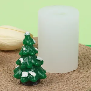 Detail view showing a finished snowy Christmas tree candle and its silicone mold