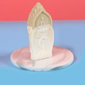 Gros plan d'une bougie sculpture de Bouddha blanche avec de fines sculptures de lotus