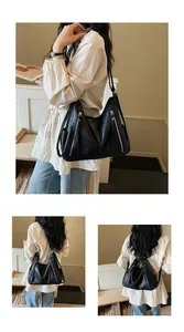 Black oversized hobo bag worn by model, showing versatile single and double strap styles.