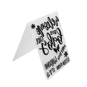 Detailed macro view of a transparent embossing folder with butterfly and baby text patterns