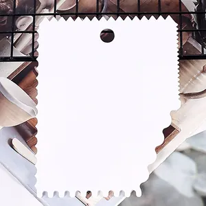 Close-up detail of a white plastic cake scraper with serrated edges for DIY baking decoration