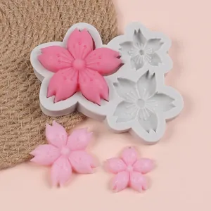 Detailed view of a cherry blossom shaped silicone mold with finished pink resin flower pieces